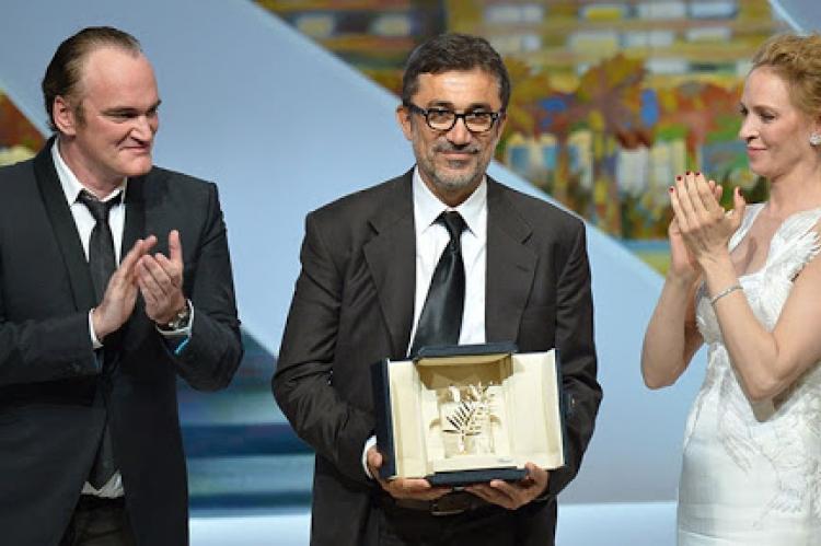 Nuri Bilge Ceylan Altın Palmiye ödülünü alırken, Cannes Film Festivali, 2014. Quentin Tarantino ve Uma Thurman ile birlikte.